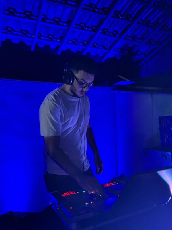 GJOTTA DJ tocando na cabine sob luz azul